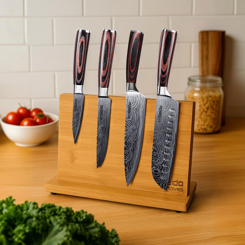 A bamboo magnetic knife holder, displayed on a kitchen table with seido knives on it.