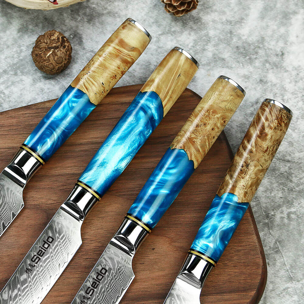 A collection of knives, featuring blue resin and brown wood handles, resting on a cutting board. Discover straight-edge steak knives.