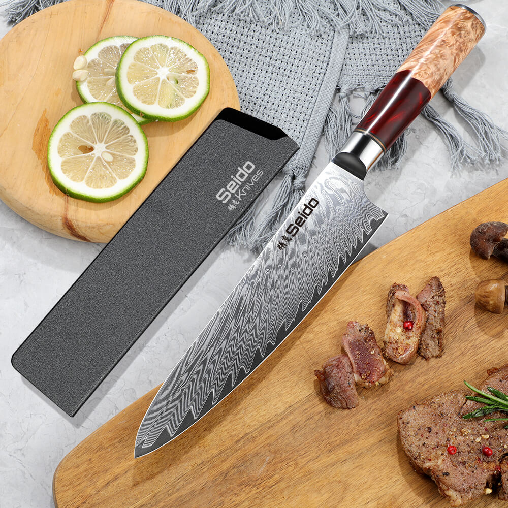 A knife on a cutting board with meat and vegetables - Experience the SEIDO™ Gyuto Japanese Damascus Steel Chef Knife.