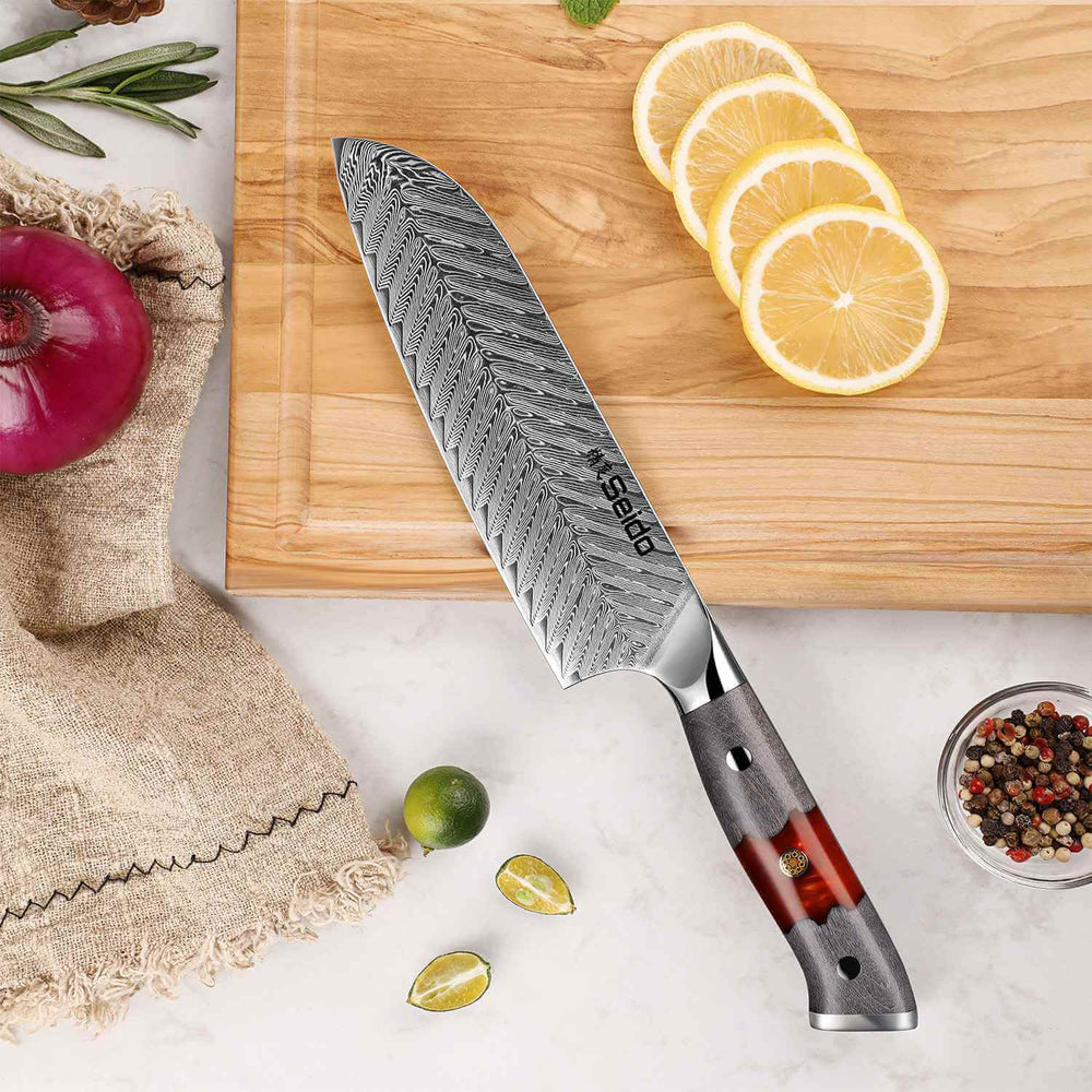 Seido Inferuno Series 7 inch Damascus Santoku Knife on cutting board