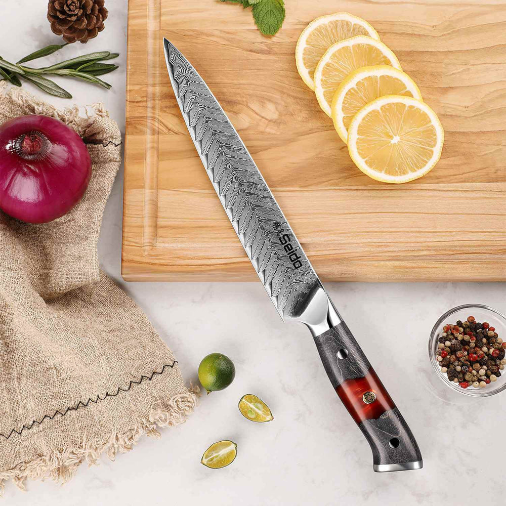 Inferuno Slicing knife with a red handle on a wooden cutting board with lemon slices and vegetables.