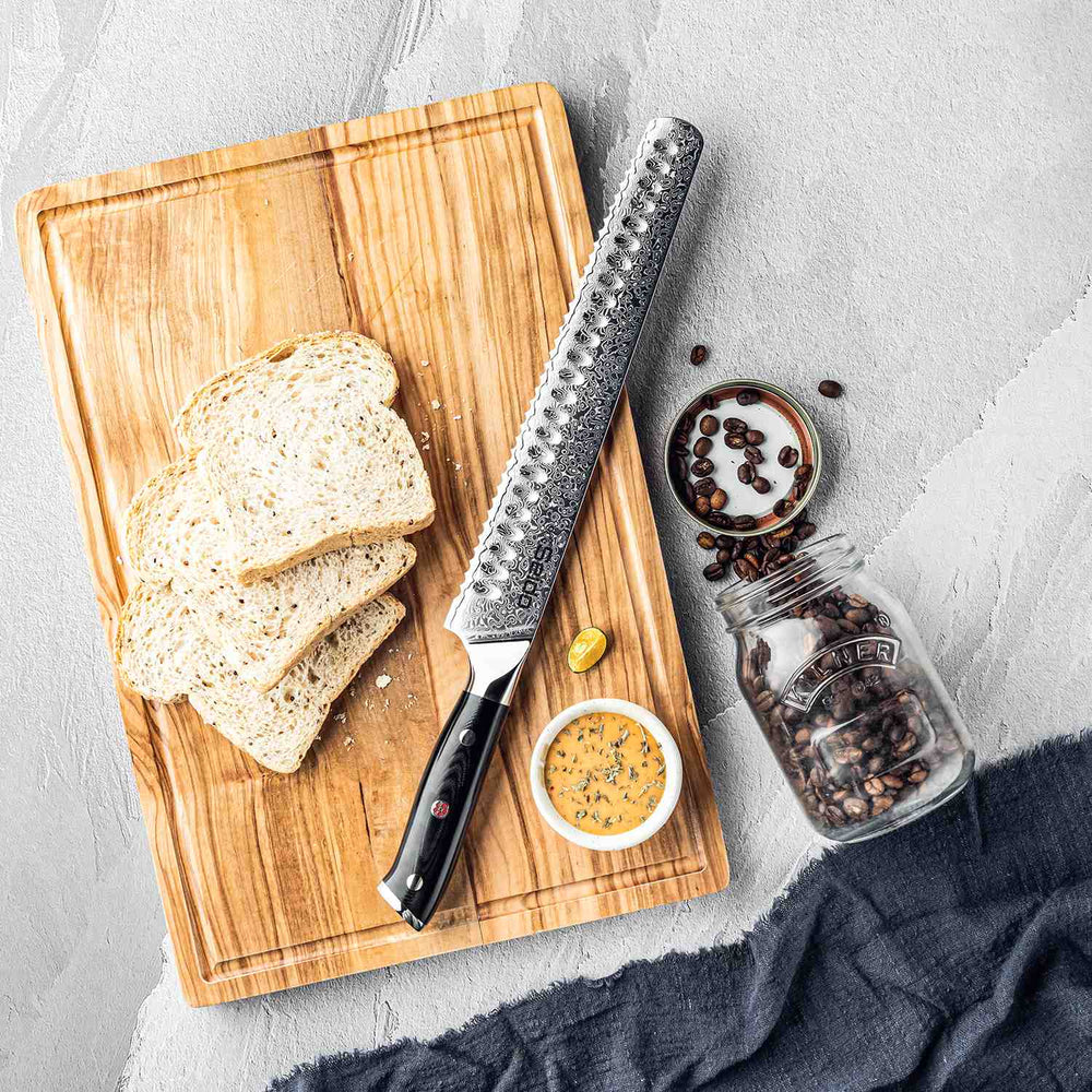 Wooden cutting board with bread slices, a knife, and a jar of spices on a gray surface.