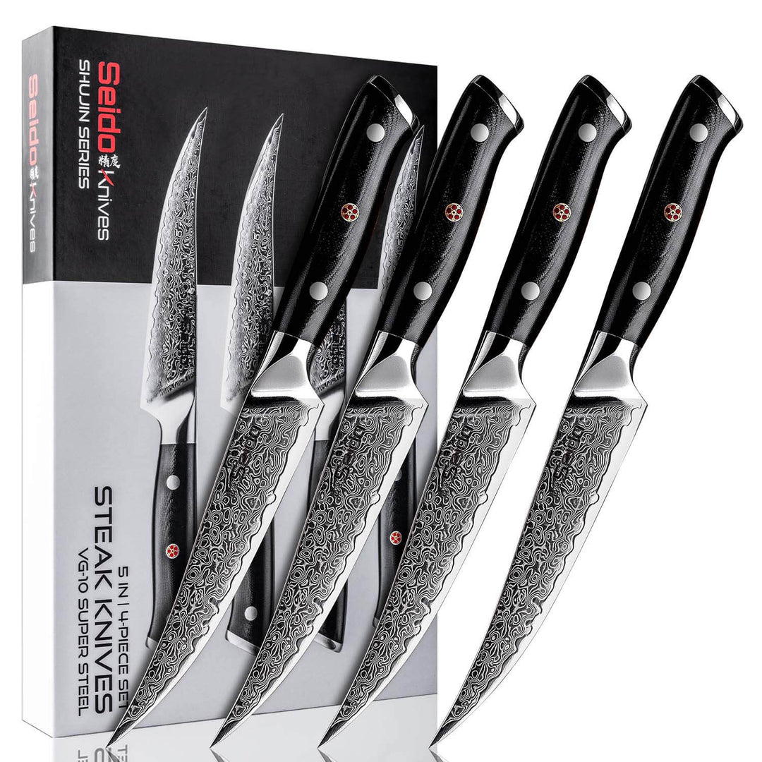A set of 4 Shujin steak knives with black G10 handles, displayed alongside their packaging.