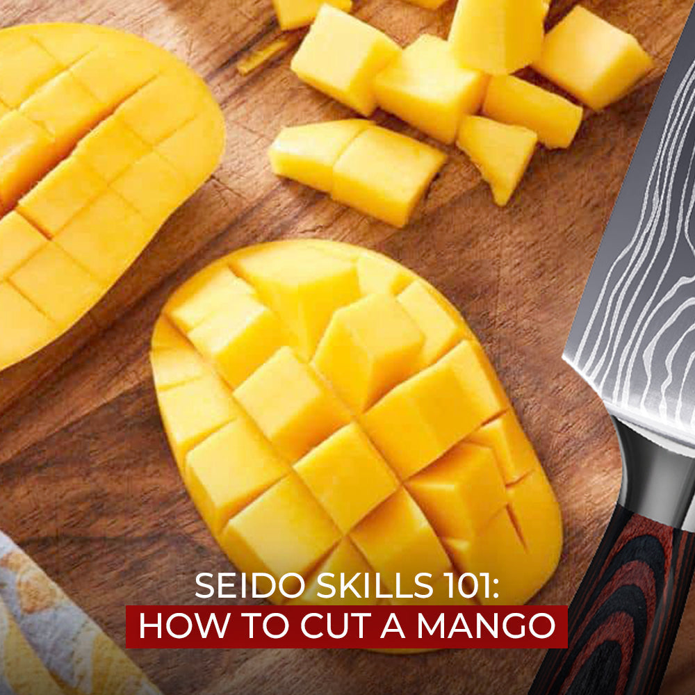 Knife slicing diced mango on a wooden cutting board.