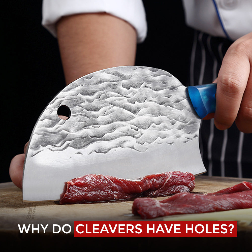 A chef cuts raw meat on a wooden board with a large, hammered-finish cleaver that has a hole in the blade.