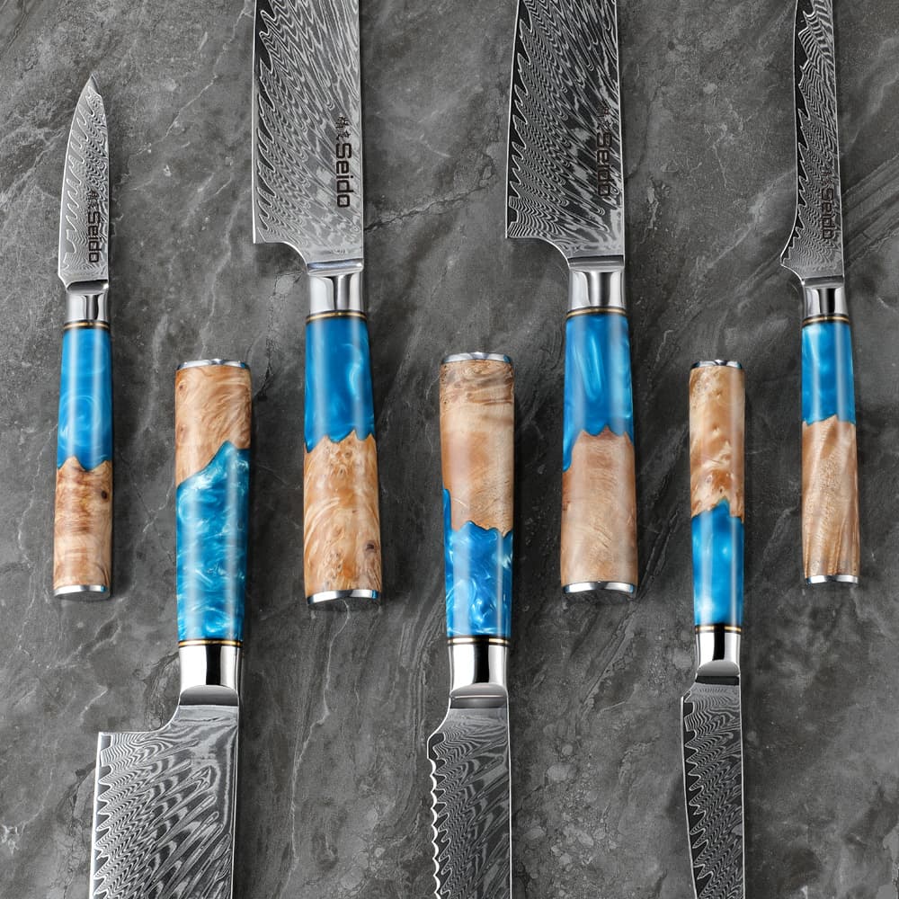 7-Piece Executive Series Knives, staggered showcasing their blue resin handles & damascus blades