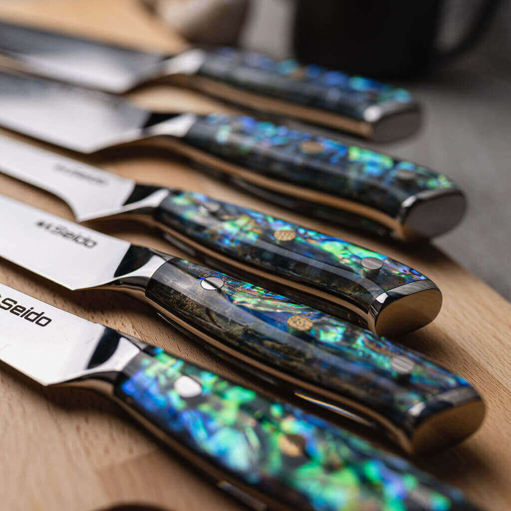 Awabi Series, 5-piece Damascus Steel Chef Knives paying on a cutting board.