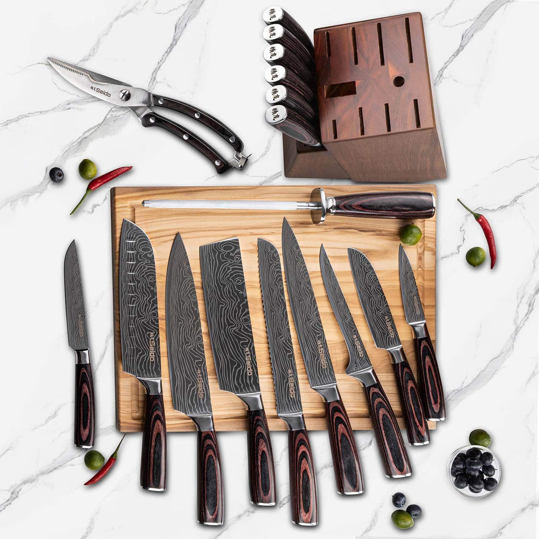 Set of knives with wooden handles on a cutting board, surrounded by vegetables on a marble surface.