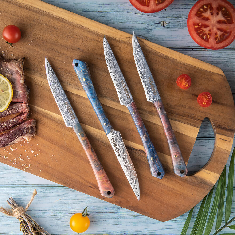 Enhance your culinary skills with Seido Knives' damascus steel steak knife set, displayed on a cutting board with a tomato.