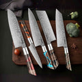 Set of five Damascus knives with wooden handles on a dark surface with vegetables.