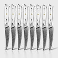 8 serrated takoizu series steak knives with damascus steel blades and white turquoise handles, arranged in a row on a light gray background.