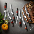 Set of 8 inferuno knives with wooden red resin handles on a gray surface with vegetables and a cutting board.