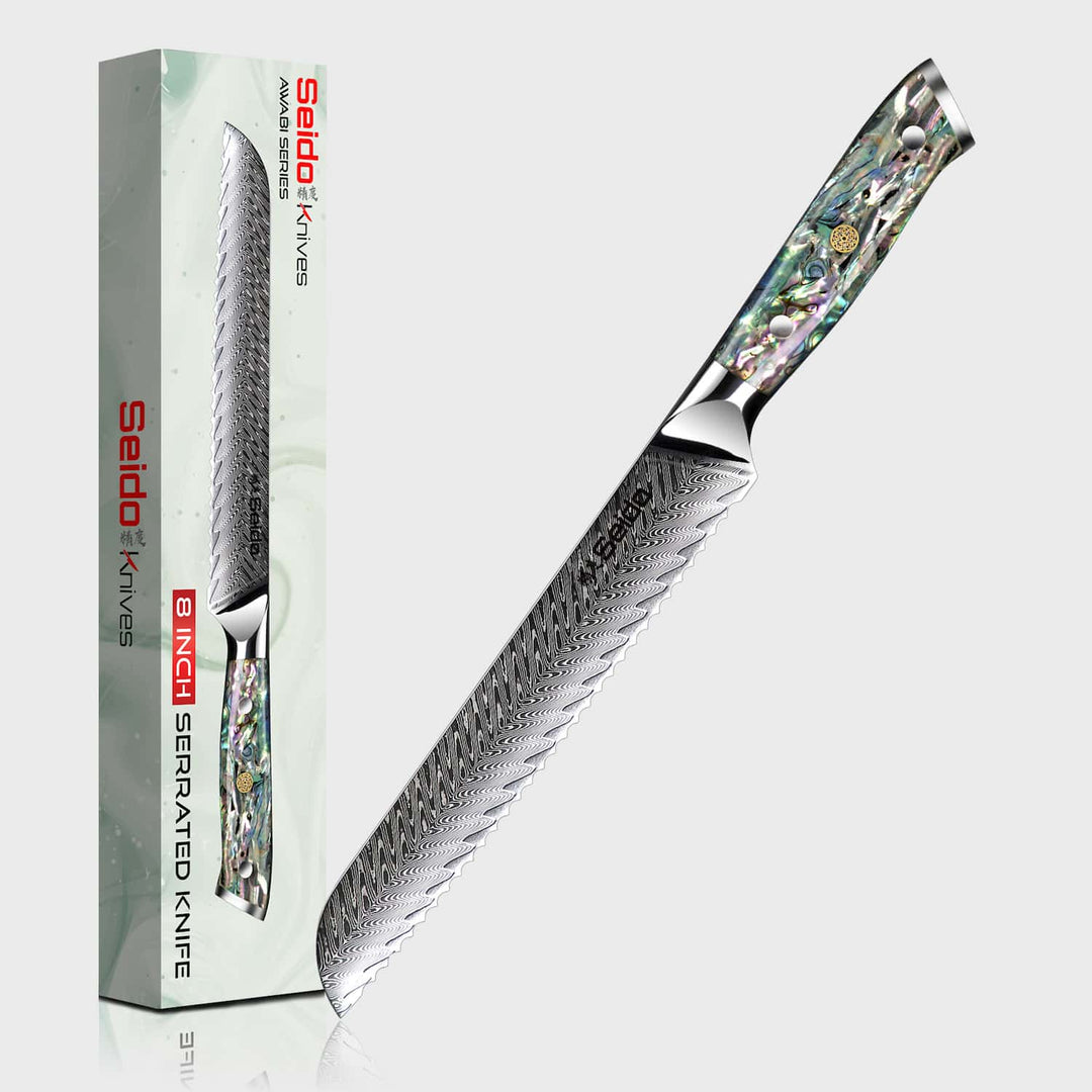 Serrated knife with decorative handle next to its packaging on a white background