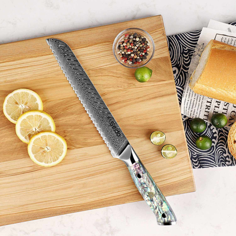 Serrated knife on a wooden cutting board with lemons and limes