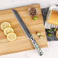 Serrated knife on a wooden cutting board with lemons and limes