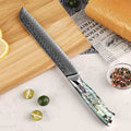 Damascus knife with a decorative handle on a cutting board with bread and lemons.