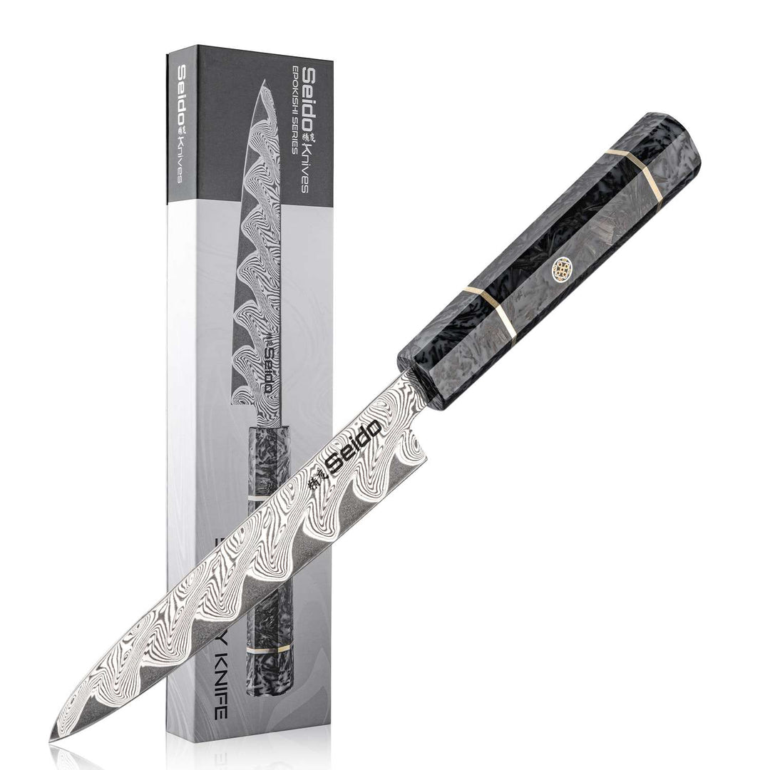 Epokishi Petty knife with a carbon fiber and grey resin handle, near its packaging on a white background.