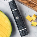 Epokishi grey resin and carbon fiber knife handle focus, near sliced mangoes.