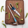 Kitchen shears on a wooden cutting board with a sharpening rod and vegetables.
