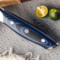 Kanpeki blue/black G10 handle close-up with mosaic pin and polished rivets, next to limes.