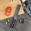 Damascus knife on a wooden cutting board with sliced tomatoes and spices