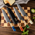 Various Kiritsuke knives on cutting board in saya knife sheath
