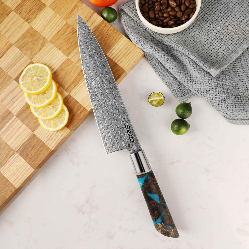 Chef's knife with a decorative handle on a cutting board with lemons and limes.
