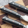 Shujin G10 handle close-up with mosaic pin and polished rivets.