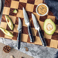 Shujin 3-piece paring knife set on a wooden cutting board with avocados and a small bowl of sauce.