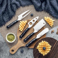 Set of four cheese knives on a wooden board with waffles and blueberries.