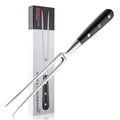 Carving fork with black handle and silver blade next to its packaging on a white background