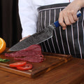 Chef cutting meat on a wooden board with a Tengoku chef knife from seido knives.