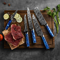 Set of tengoku knives with blue handles on a wooden cutting board with sliced lemon and raw meat.