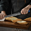 Person slicing bread with a serrated tangoku knife on a wooden cutting board