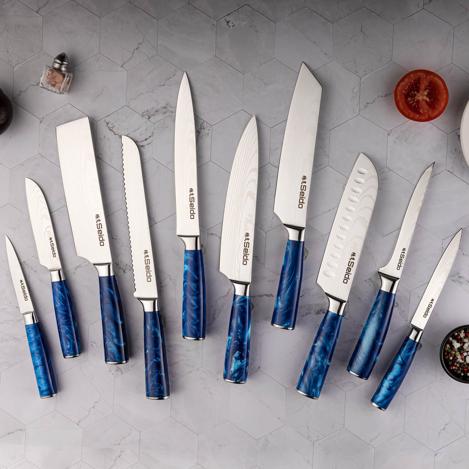 Behold the Tengoku Chef Knife Set from Seido Knives! A collection of knives with blue handles, arranged on a counter.