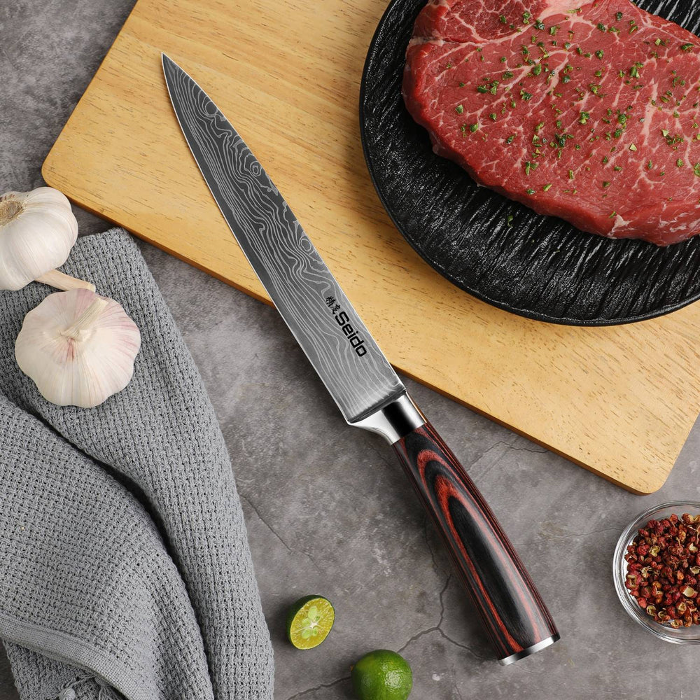Master 8-inch slicing knife beside steak, garlic and fresh ingredients on a wooden cutting board