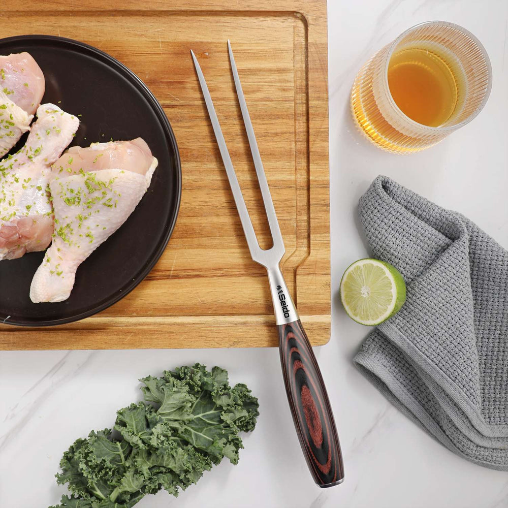 Master Series meat and carving fork beside poultry on a wooden carving board
