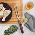 Master Series meat and carving fork beside poultry on a wooden carving board