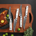 Four Takoizu steak knives arranged on a wooden serving board