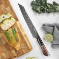 Titan Serrated Knife displayed with artisan bread and leafy greens