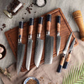 Slice and dice with style! Seido Knives' Hanikamu 7 Piece Damascus Chef Knife Set, elegantly displayed on a cutting board.